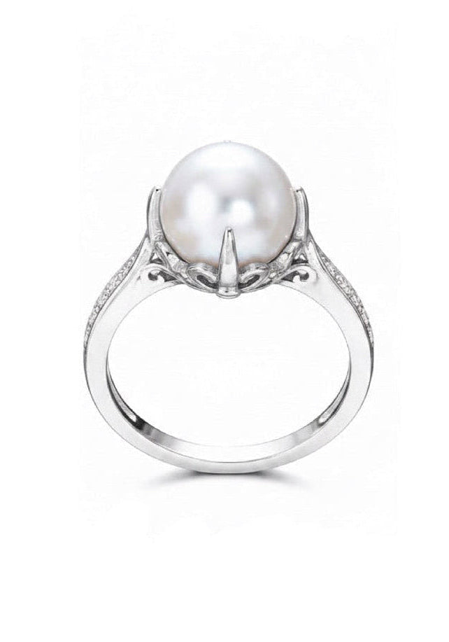 A silver ring featuring a large white pearl in a prong setting with small clear stones along the band, shown against a plain white background.