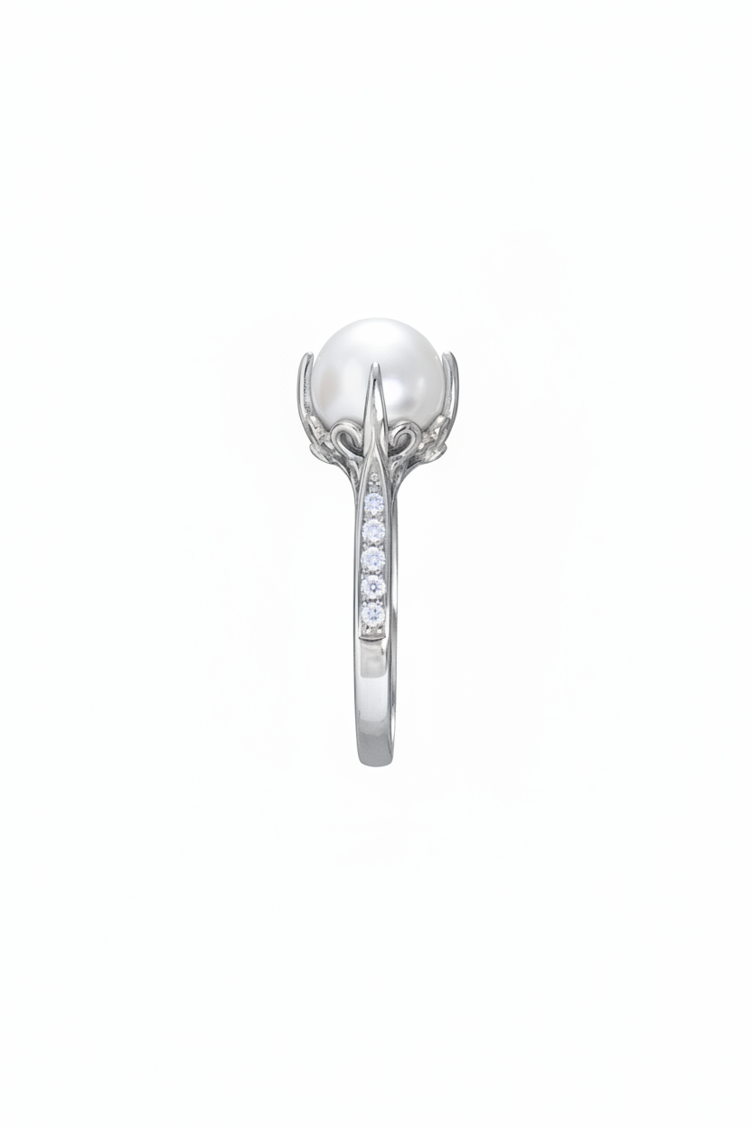 A silver ring featuring a large white pearl held in a claw setting, with a channel of small clear stones along the band, shown against a plain white background.