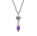 A silver chain with a silver heart and an Amethyst crystal pendant against a white background. 