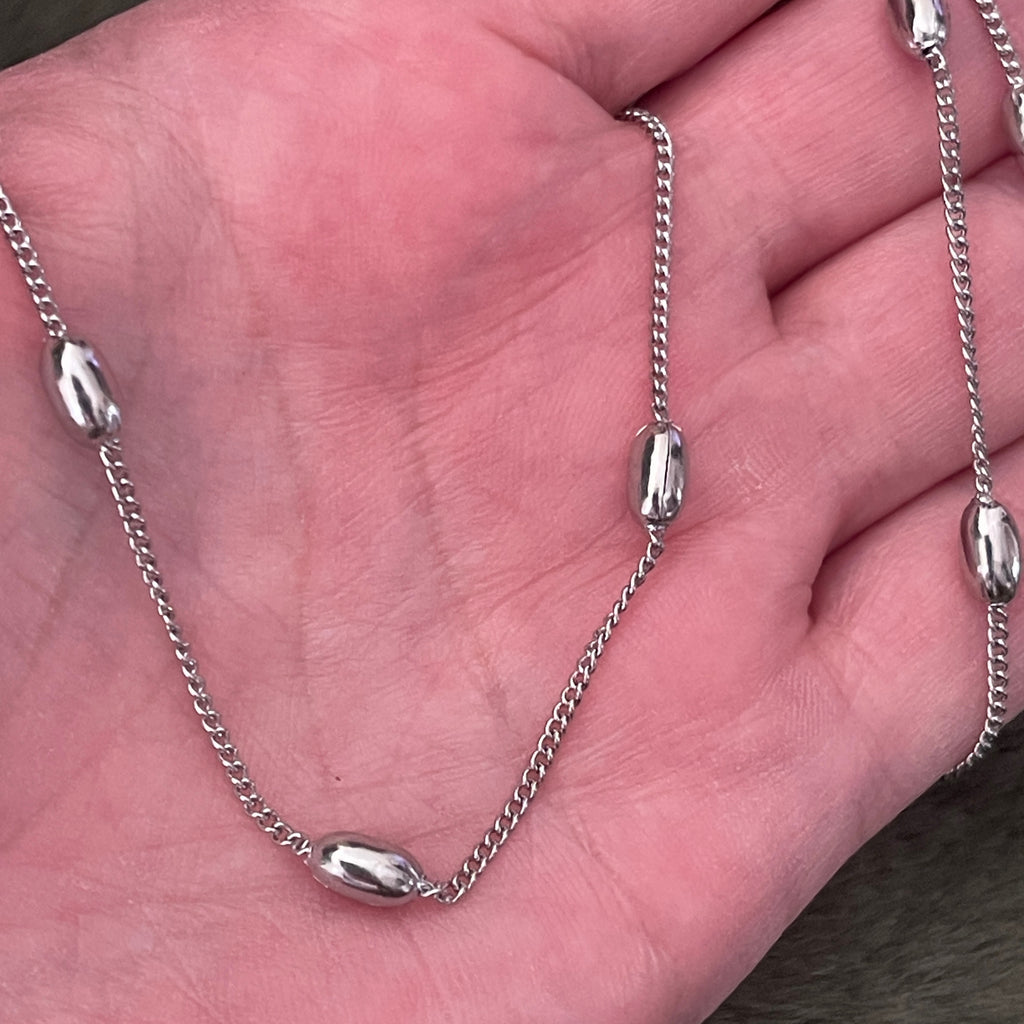 Silver chain necklace on a hand