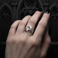 Silver ring with star and moon design on a hand against a dark background