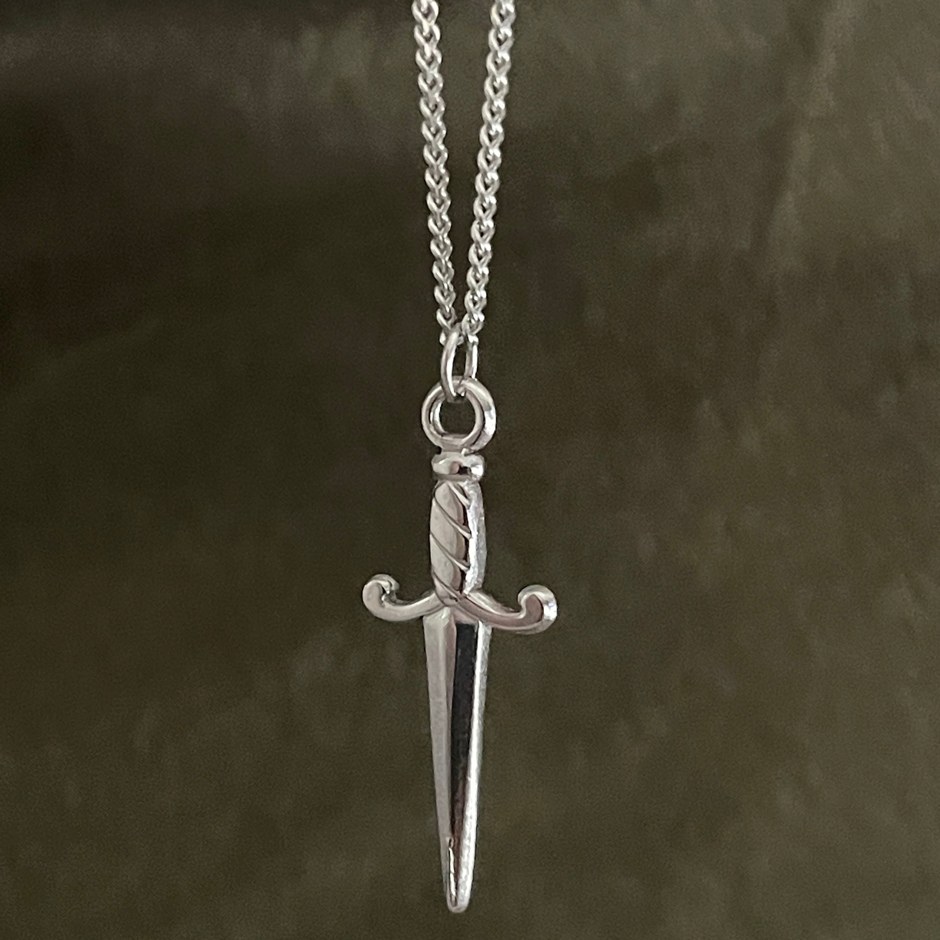 Silver sword pendant necklace on a dark background