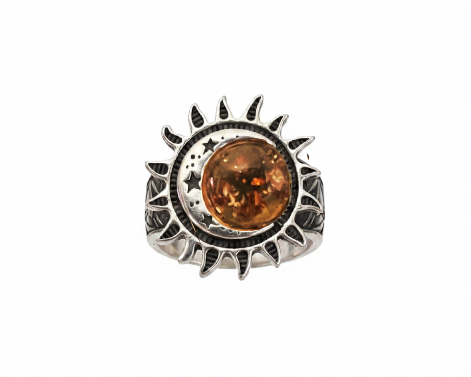 Silver ring with sun, moon and star detail with a round amber gemstone on a white background. 